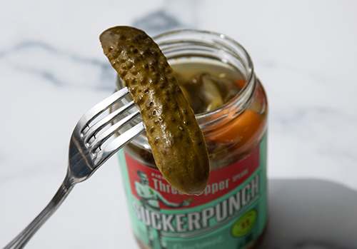 Pickle being pulled out of a jar.
