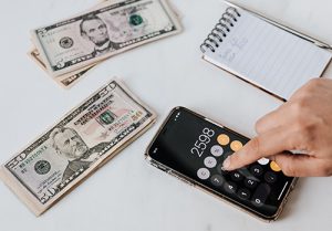 A person calculates the amount of money to save.