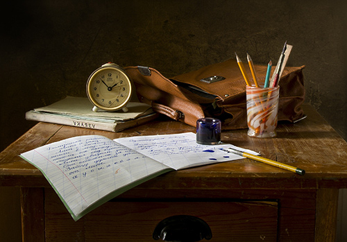 A writing notebook and other office items are present on a desk.