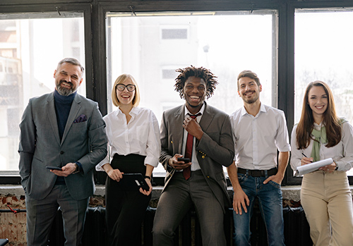 Office workers in different business attire pose for a photograph.