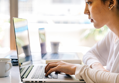 Woman works on computer while visiting an accessible website.