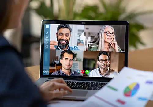 Four smiling faces on a video conferencing call.